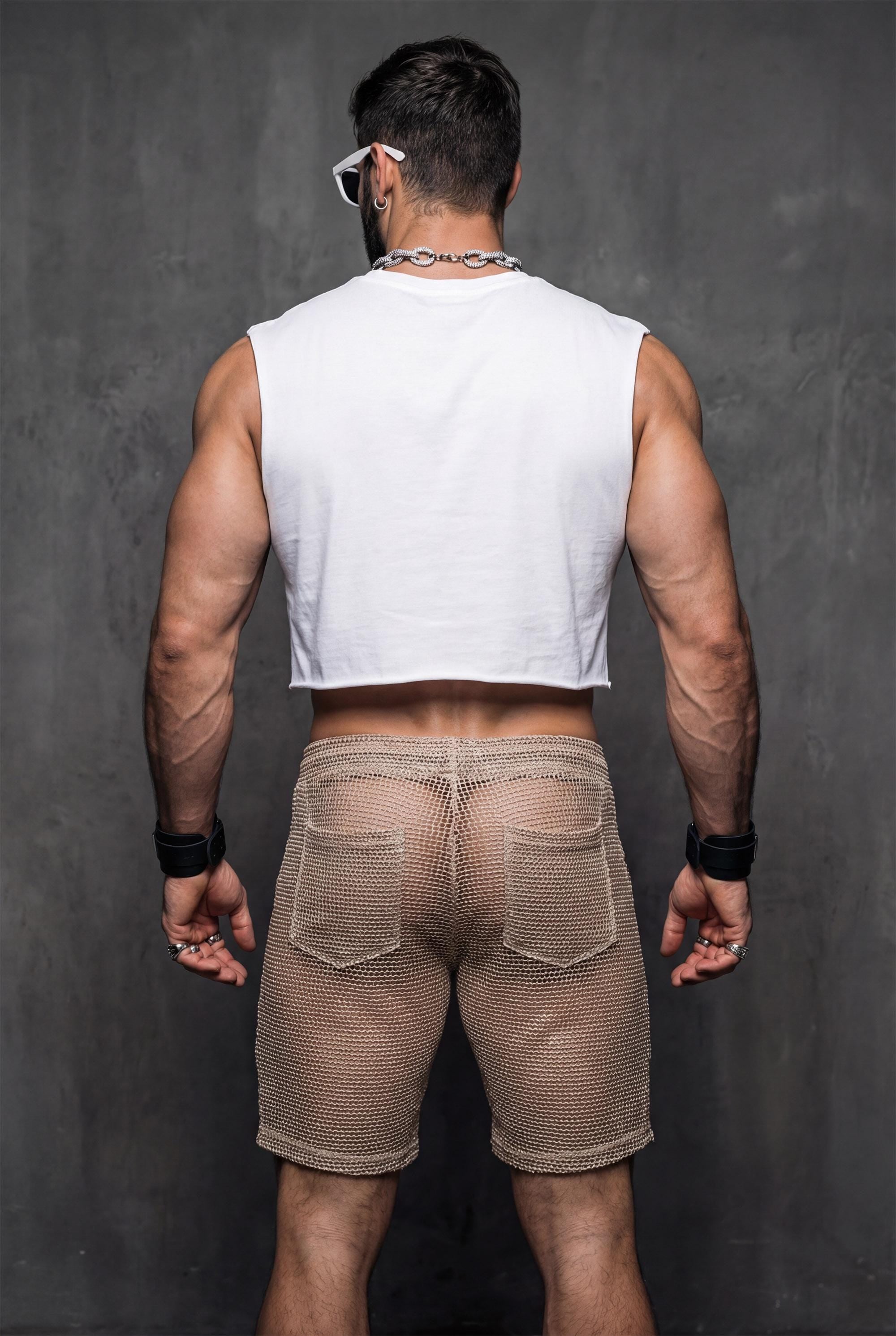 Back view of transparent black mesh shorts on a muscular man. Sheer fabric emphasizes curves and leg definition. Perfect for gay club wear, Berlin party scene, circuit events, and fetish-inspired nightlife. Bold mesh shorts for men seeking sexy, provocative, and breathable party clothing with strong visual impact.