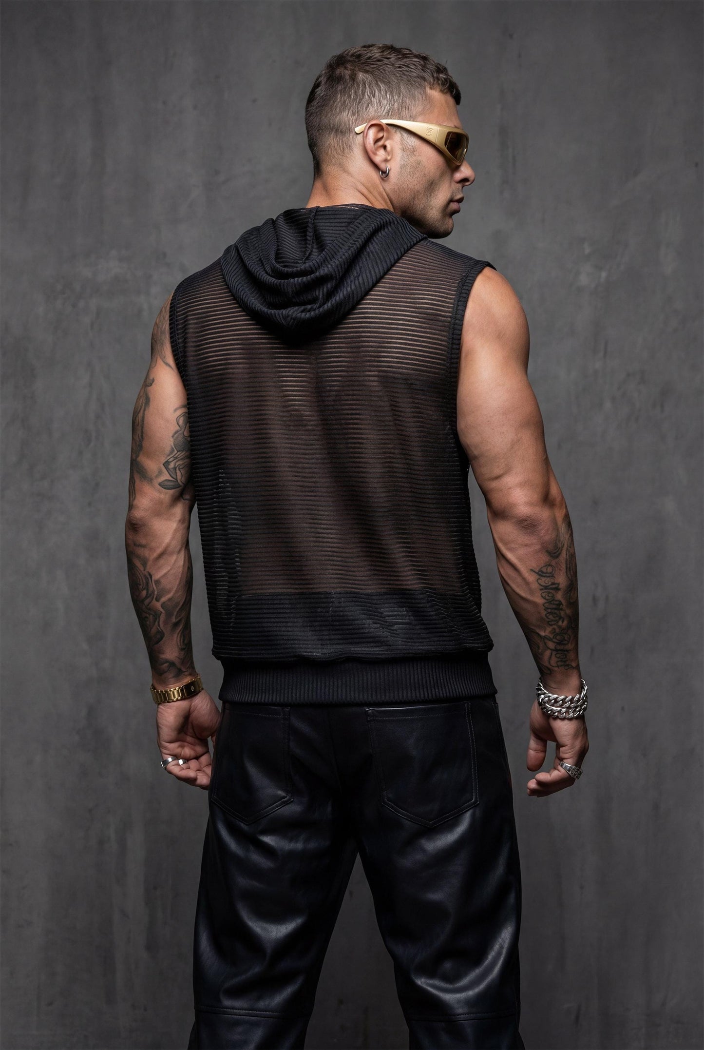 Size chart for men's black hooded sheer tank showing one-size-fits-most measurements for S-L bodies. Transparent mesh sleeveless top sizing guide helps choose perfect fit for festival outfits, rave wear, and pride clothing. This hooded tank measurement reference ensures relaxed comfortable fit for gay clubwear and LGBTQ+ event wear. Detailed dimensions for chest, length, and hood specifications in breathable metallic-striped mesh construction.