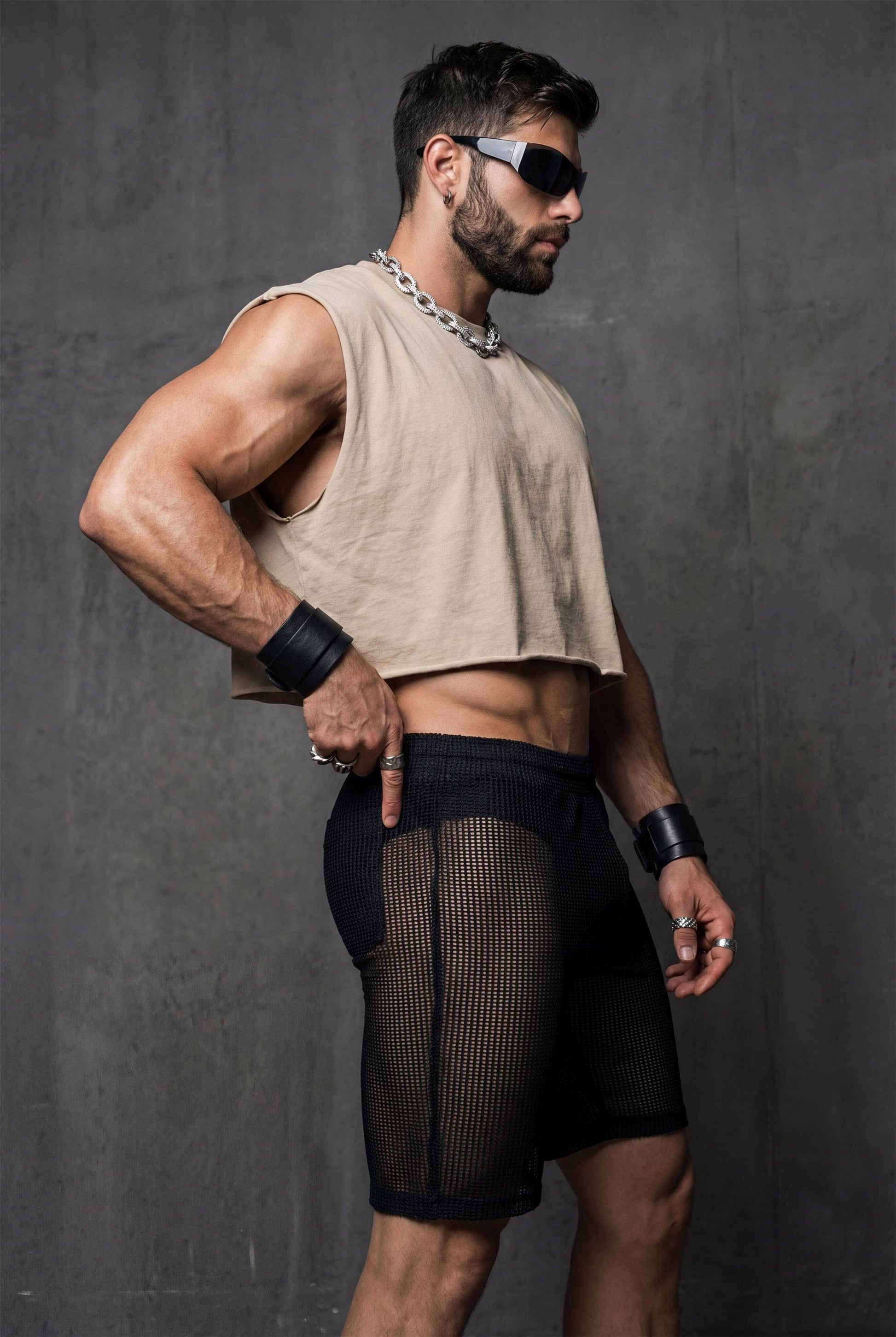 Side profile of see-through mesh shorts on a toned male body. Lightweight mesh follows the legs and highlights muscle definition. Ideal for gay party looks, Berlin underground clubs, raves, and festival wear. Transparent club shorts made for dancing, heat, and high-energy LGBTQ nightlife scenes.