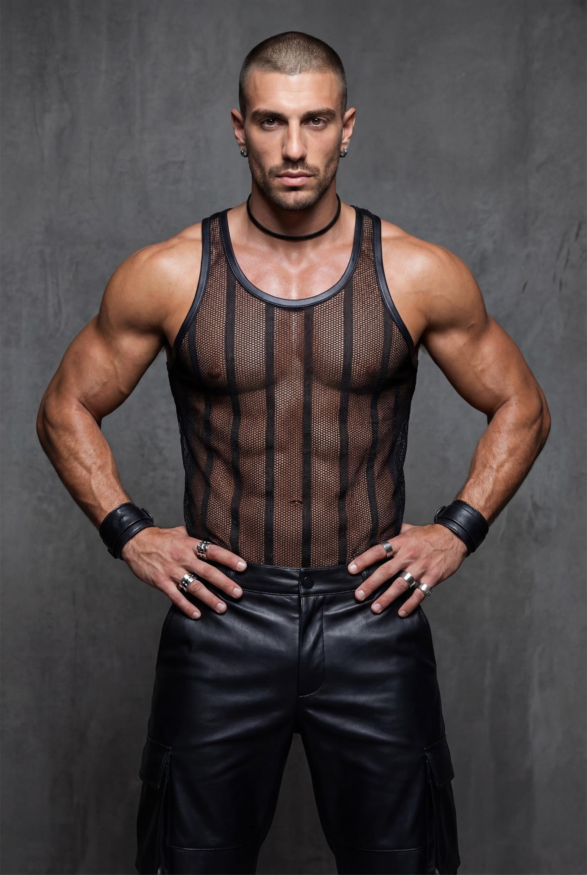 Muscular man wearing a black transparent mesh tank top for men, side profile view. See-through racerback stringer reveals chest and abs through breathable polyester mesh, with luxe polyamide collar. Black club party wear styled with leather pants, ideal for gay club nights, pride events, circuit parties, rave festivals and bold men fashion.