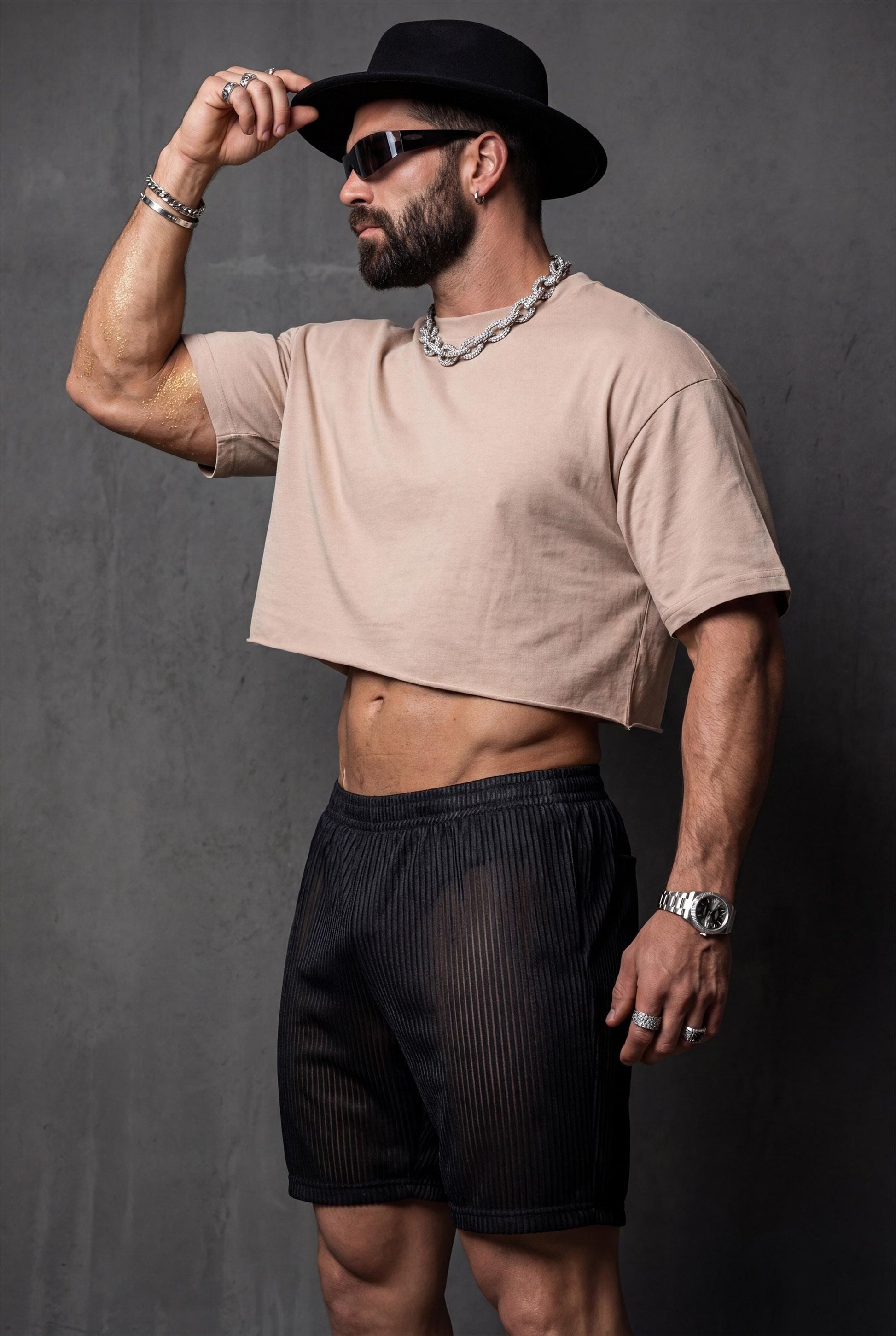 Black sheer mesh shorts men with metallic pinstripe in nightclub setting catching neon lights for gay clubwear and rave fashion. Semi-transparent ribbed construction shimmers under club lighting. Perfect for circuit parties, techno clubs, pride after-parties, and underground nightlife. Bold piece for dance floor with confident shimmering transparent aesthetic.