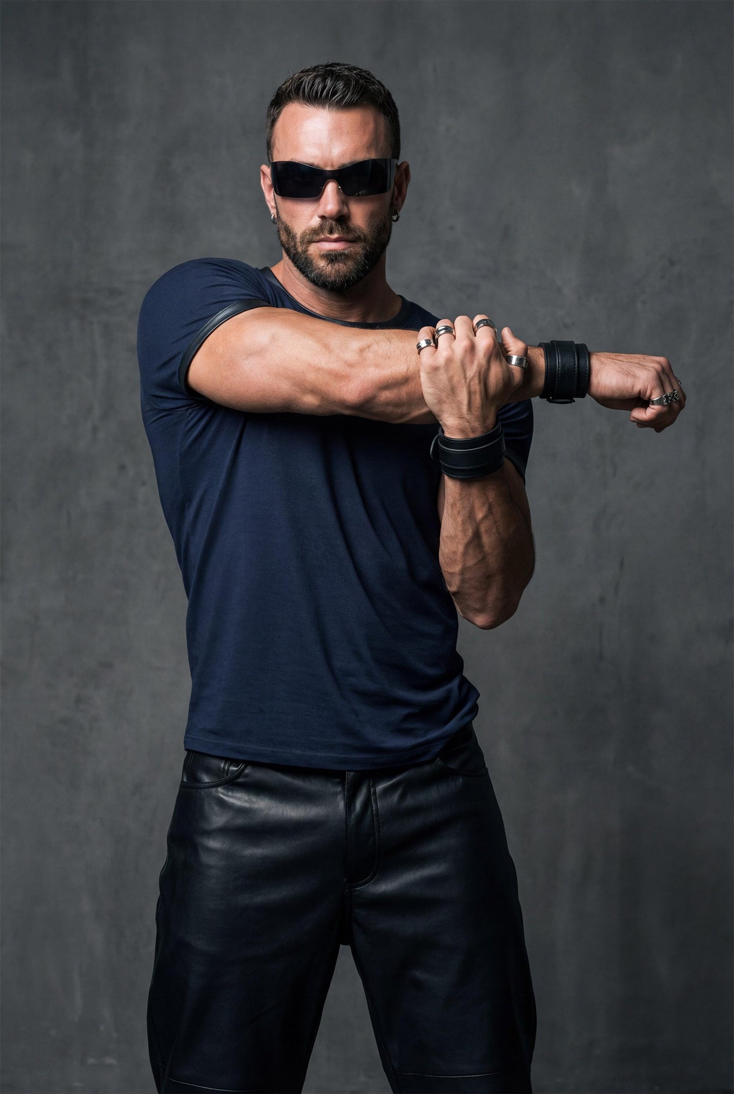 Navy blue modal t-shirt men front view tucked into black pants showing faux leather trim details. Premium designer tee with contrast collar and sleeve edges perfect for smart casual style. This fitted crew neck shirt combines soft modal fabric with edgy leather accents ideal for elevated streetwear, date nights, or business casual outfits. Versatile men's fashion combining comfort with sophisticated