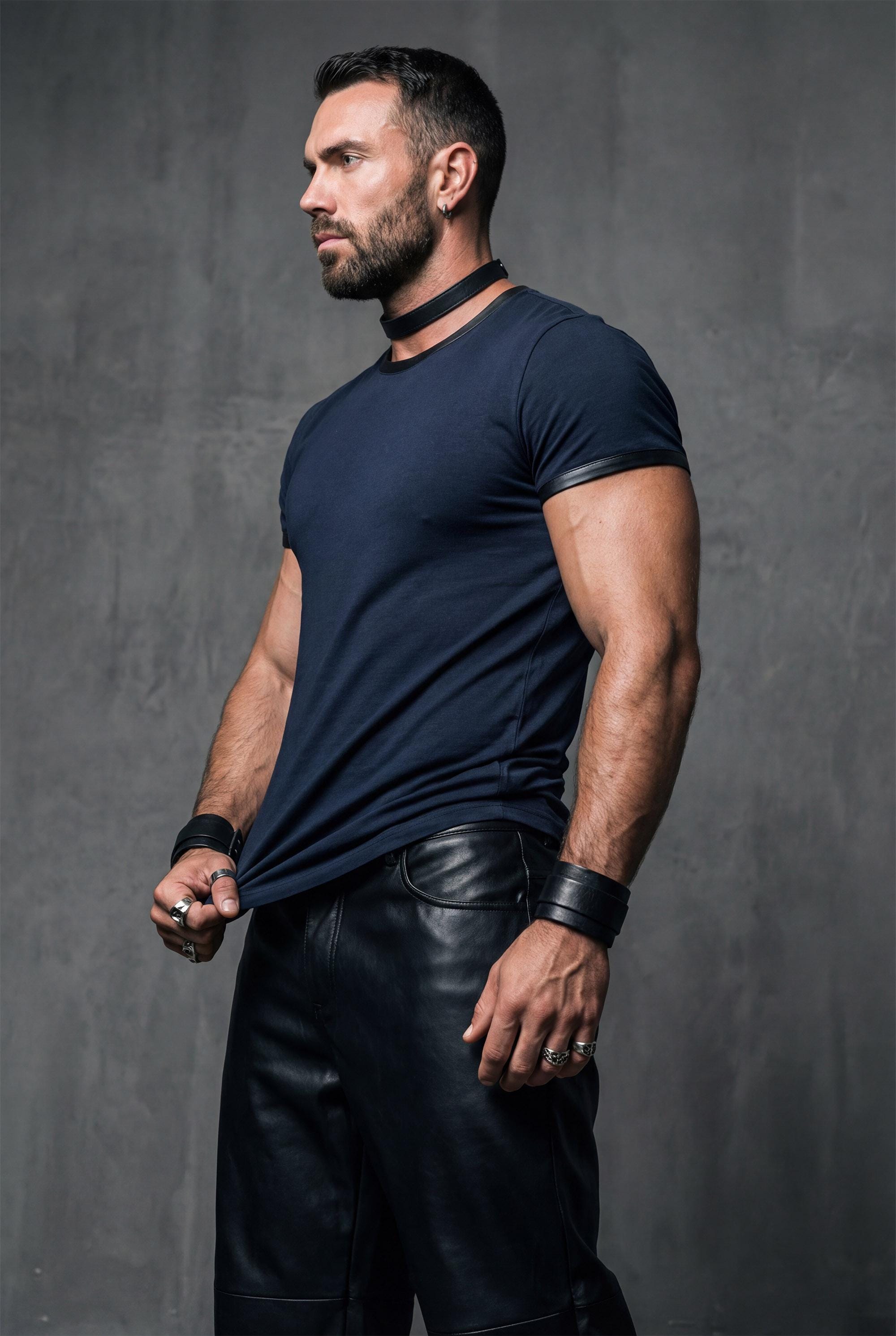 Side profile of navy blue modal tee untucked in showing fitted silhouette and faux leather sleeve trim detail. Designer men's shirt with premium fabric drape perfect for smart casual occasions. This crew neck t-shirt creates polished look when styled with chinos or dress pants. Elevated streetwear combining soft modal construction with edgy leather accents for fashion-forward men seeking quality basics.