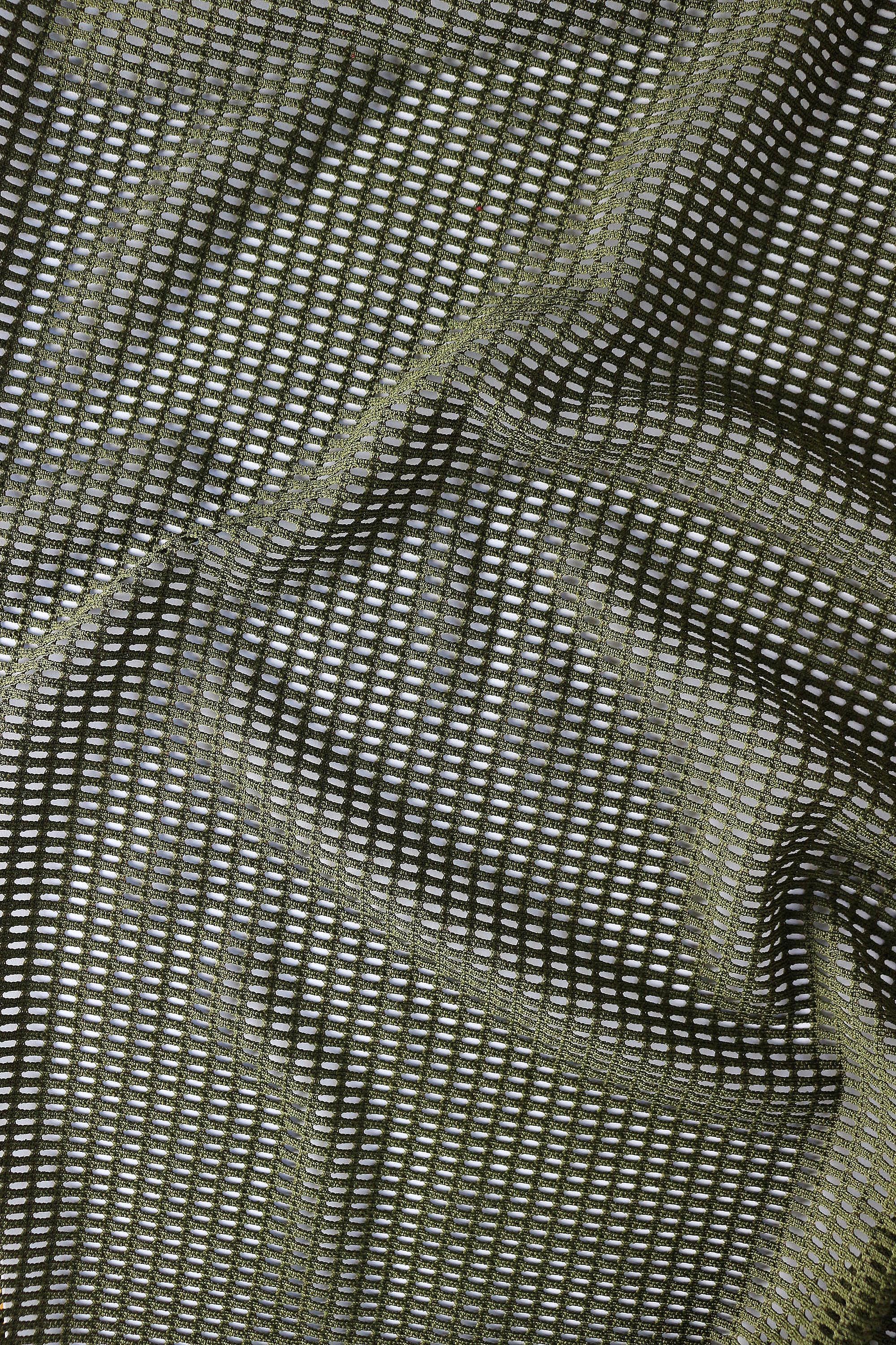Close-up detail of breathable mesh fabric texture in olive green for lightweight rave crop top men
