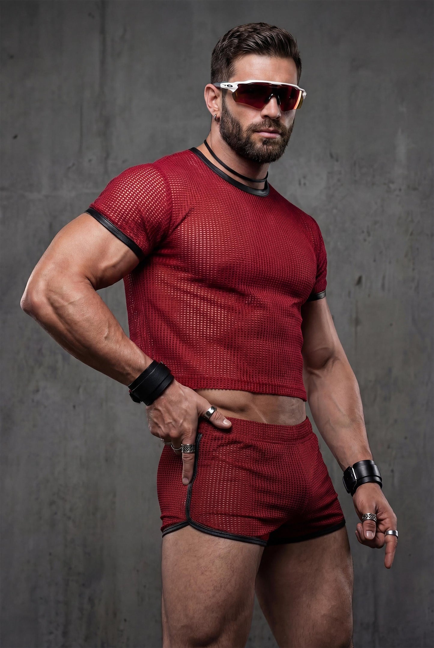 Side angle red sheer mesh crop top with contrast black trim and fully transparent shorts showing athletic body fit - PIEL complete gay festival outfit for circuit parties underground clubs - see-through breathable fabric designed for dancing movement comfort - queer menswear statement piece perfect for pride parades rave events techno parties fetish clubs - bold red color catches attention under club lights strobes