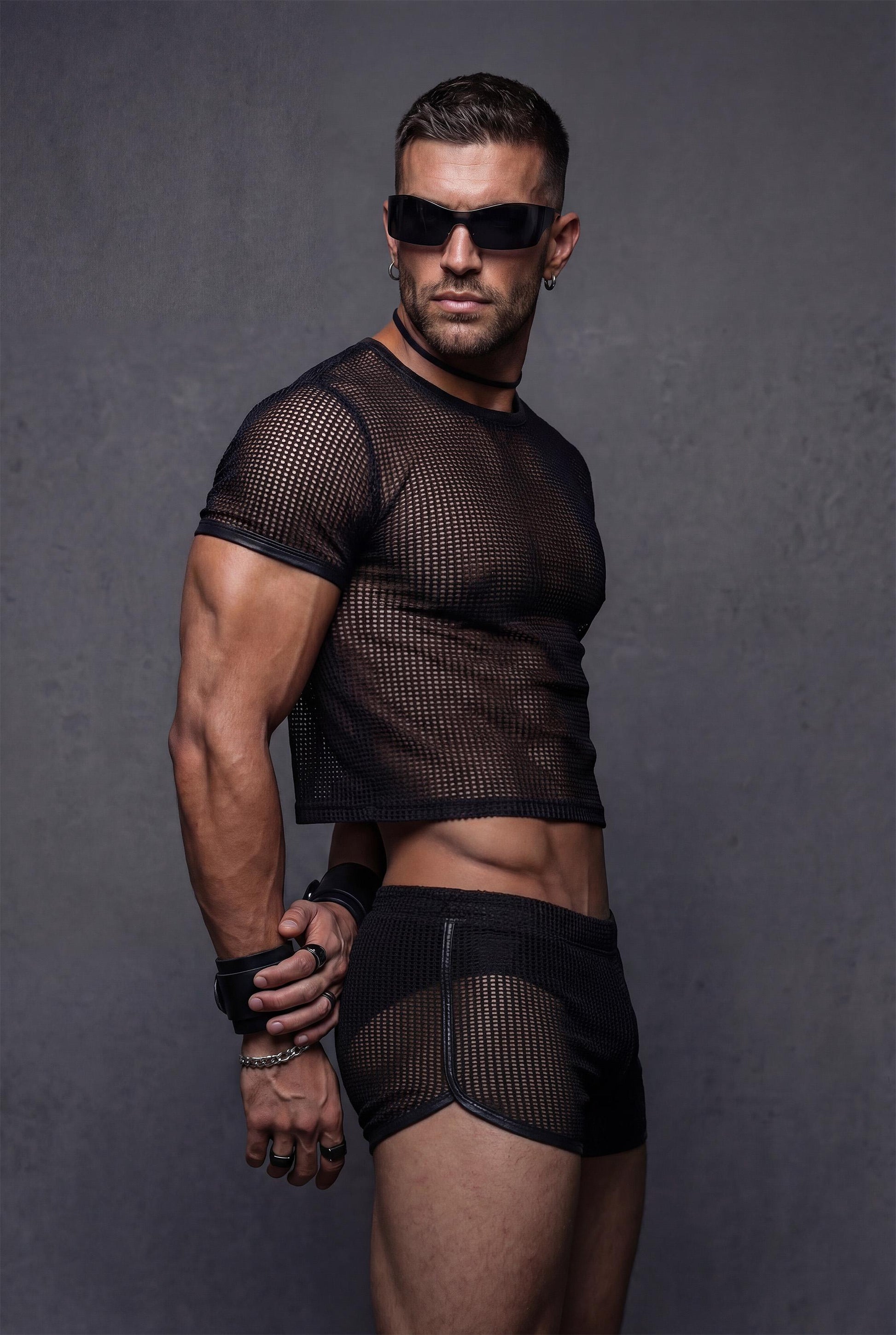 Side profile view black transparent mesh crop top with vegan faux leather contrast trim paired with see-through shorts - PIEL Night Starter bundle for gay circuit parties rave festivals - athletic body-hugging fit shows masculine physique - queer fashion statement piece for techno clubs underground parties pride celebrations burning man outfits - breathable sheer fabric designed for dancing all night