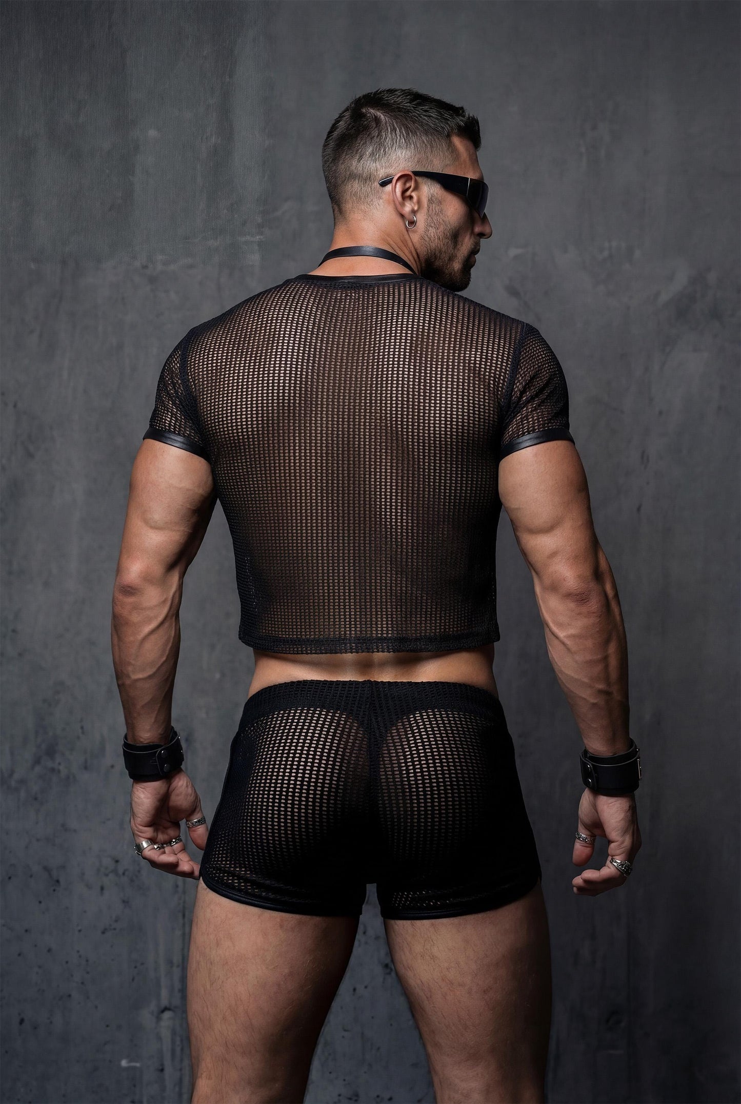 Back view black sheer mesh crop top and transparent shorts displaying athletic cropped fit and breathable see-through construction - PIEL gay party wear for circuit events rave festivals - masculine queer fashion showing body confidence - perfect outfit for techno clubs pride parades fetish parties beach sessions - polyester mesh fabric with vegan leather details designed for bold lgbtq style statements and festival wear