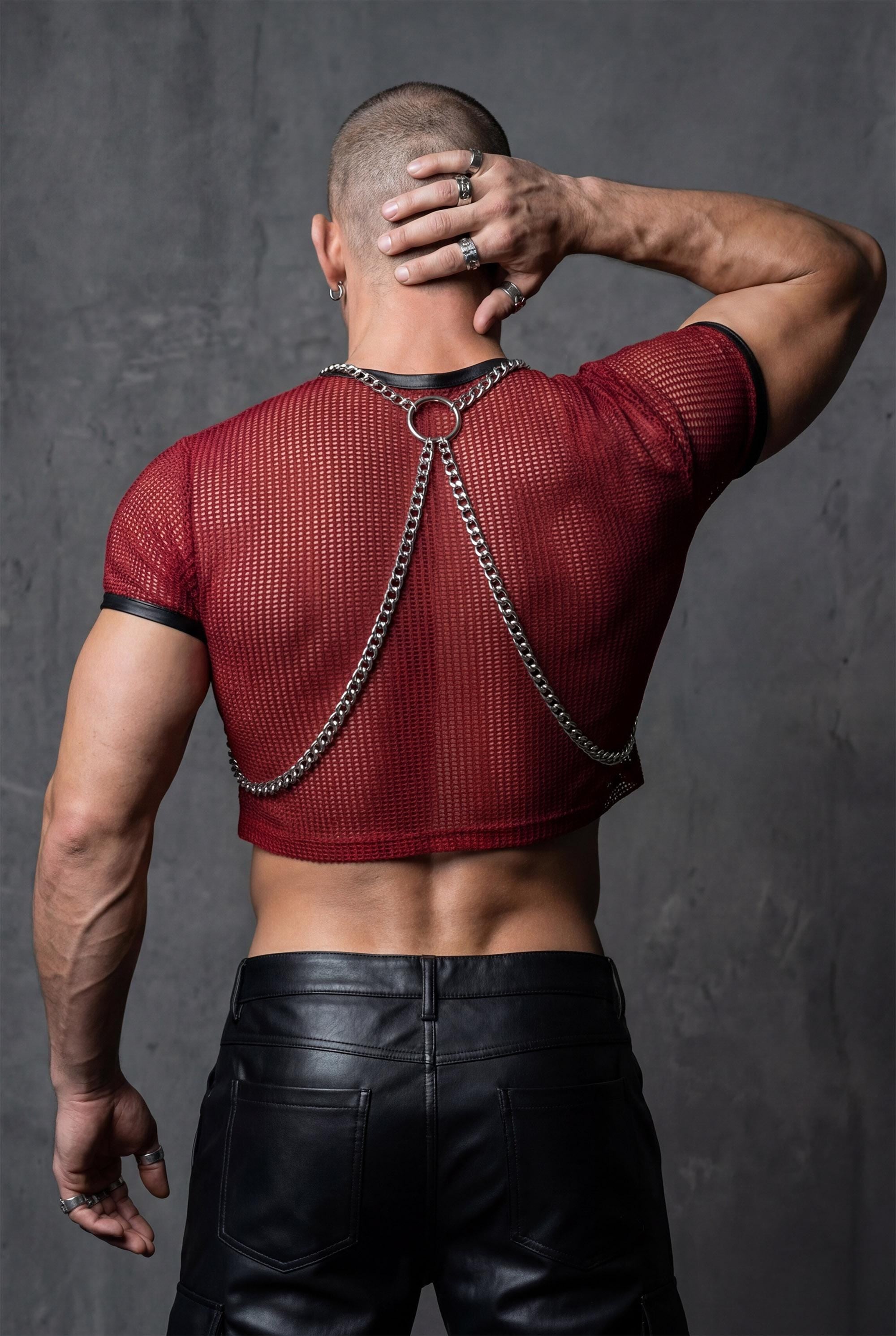 Men's aluminum suspender harness rear angle, chain straps visible on back, black pants, gay pride jewelry