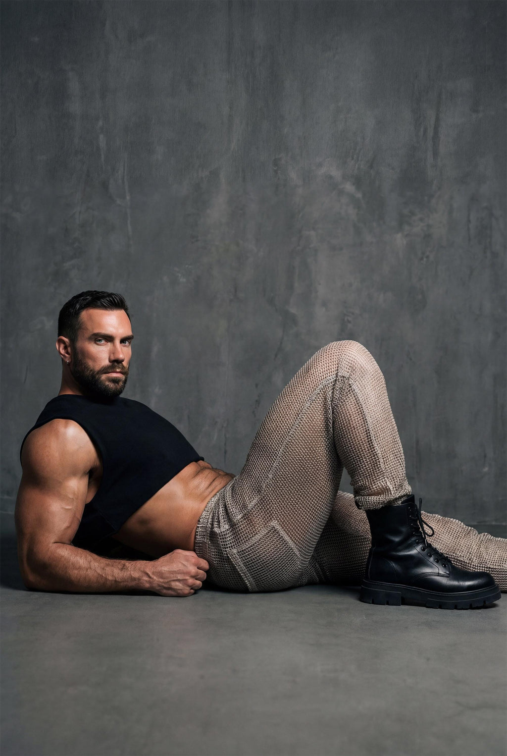 Beige see-through knit mesh jogger pants men with elastic cuffs and drawstring waist, perfect for gay casual wear, rave festival outfit, and relaxed summer style. Breathable open-knit fabric offers ventilation while creating unique textured look. Available in beige and black. Ideal for beach parties, festival lounging, pride events, and casual clubwear. Elastic waistband ensures comfort. Statement piece for men who embrace bold transparent fashion with laid-back confidence and individuality.