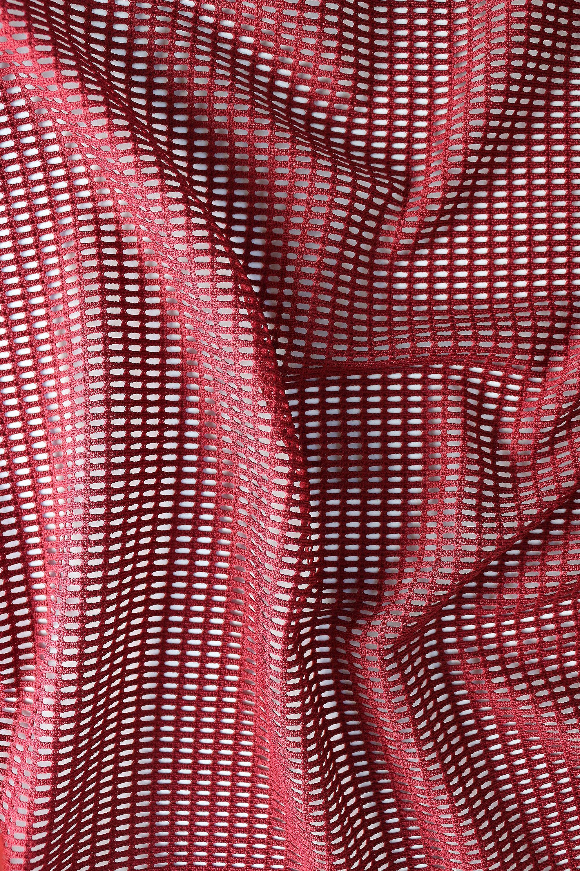 Close-up detail of breathable mesh fabric texture in burgundy red for rave shorts men